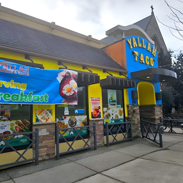 Exterior of Yallah Taco, a vibrant yellow and blue building with a large "Yallah Taco" sign.