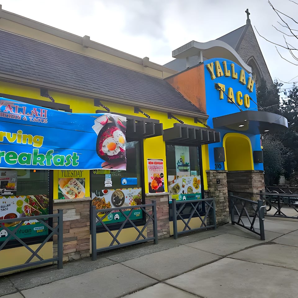 Exterior of Yallah Taco, a vibrant yellow and blue building with a large "Yallah Taco" sign.